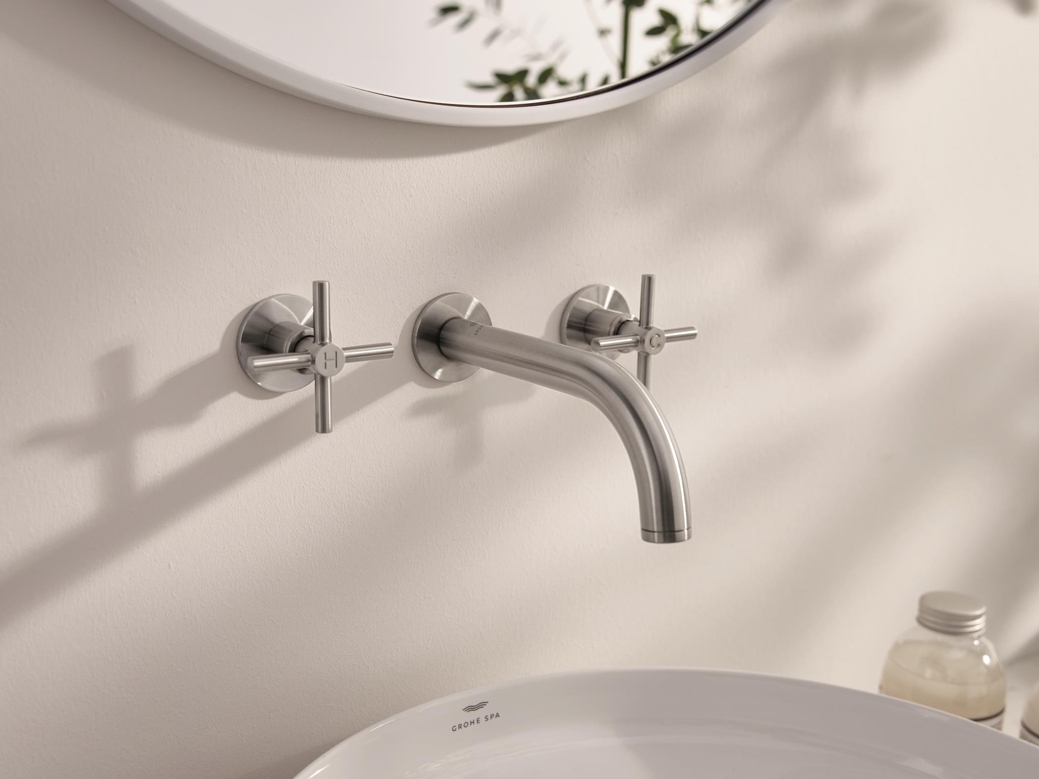 Close-up of a modern,wall mounted, Chrome Atrio tap with 2 handles.